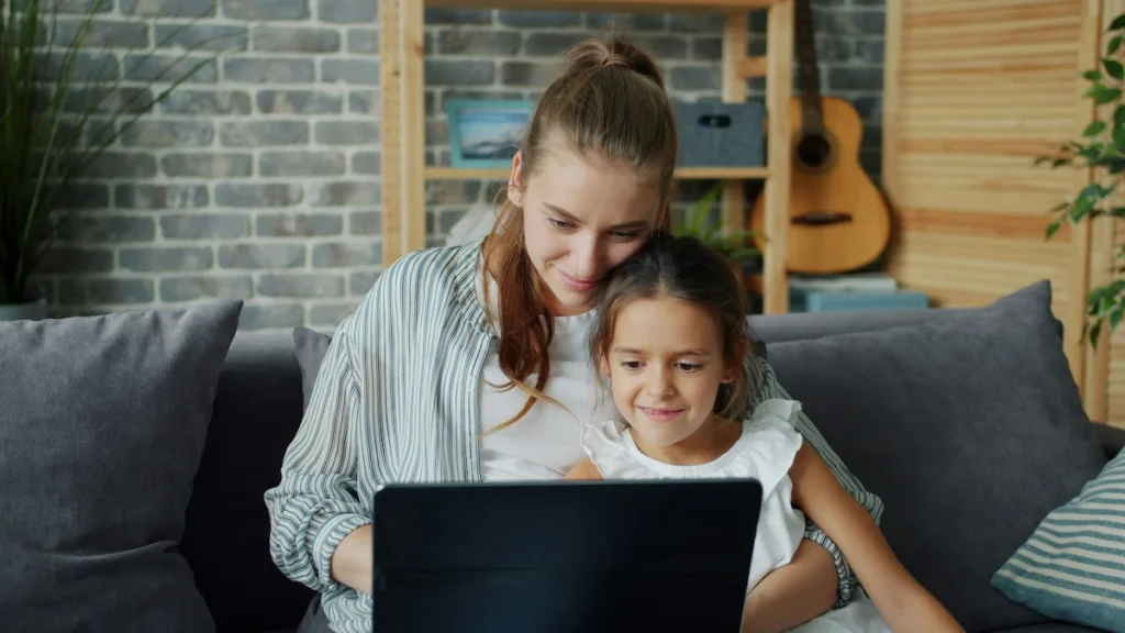 Mother and daughter learning together on laptop at home