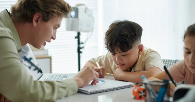 Parent teaching two children at organized homeschool table during structured learning time