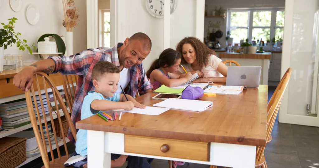 Parent-led homeschool learning at a kitchen table with elementary-age children