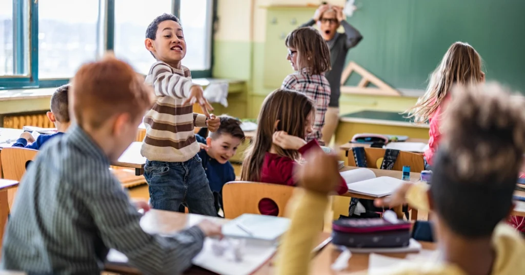 Students misbehaving in a classroom while others try to focus on their work
