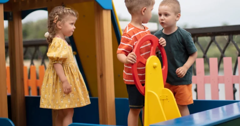 Young children interacting independently on a playground, showing natural social development and peer interaction