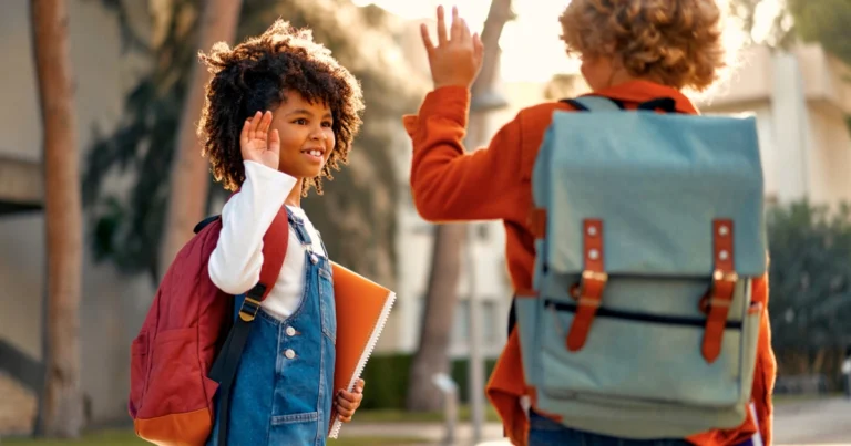 Children saying goodbye outside of school as their friendship changes during a transition away from traditional schooling