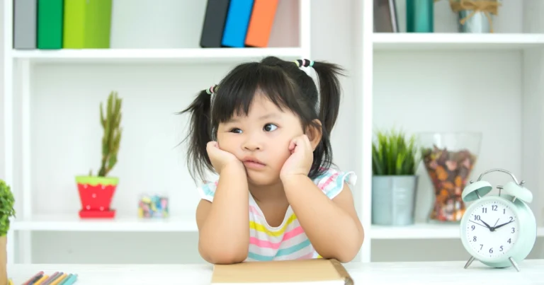 Young homeschool child sitting at a desk looking unsure what to study during a child-led learning session.